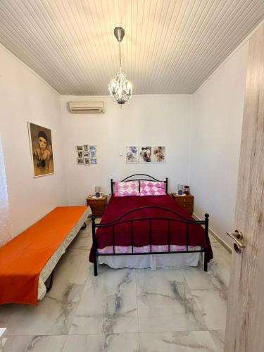 a bedroom with a bed and a chandelier at Domi's Cottage in Agia Triada