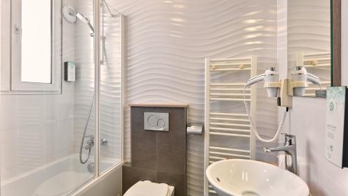 a bathroom with a shower and a sink and a toilet at Campanile Prime - Paris 14 Maine Montparnasse in Paris
