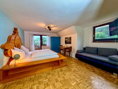 a bedroom with a large bed and a couch at Kleiner Urlaub in Beuron