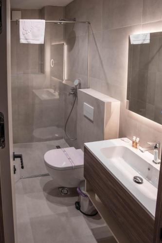 a bathroom with a toilet and a sink and a shower at Hotel Onogošt in Nikšić