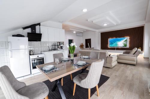 a kitchen and living room with a table and chairs at Premium Stay Prishtina in Prishtinë