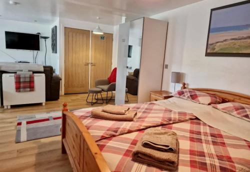 a bedroom with a large bed and a living room at The Annexe At The Old Mill in Camborne