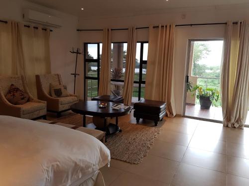 a bedroom with a bed and a table and chairs at The Residence Chobe Villa in Kasane