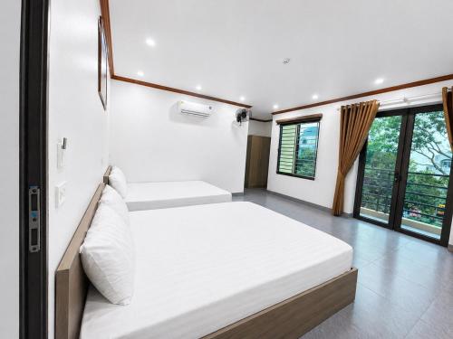 a bedroom with two beds in a room with windows at Đức Quỳnh Hotel in Ninh Binh