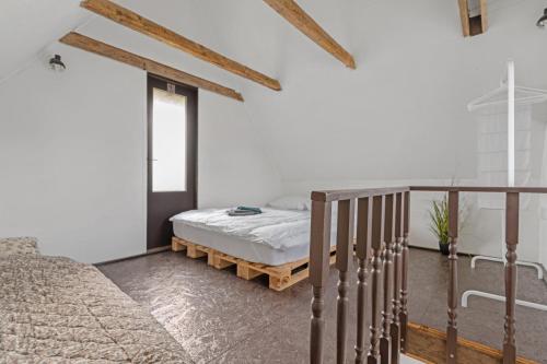 a bedroom with a bed and a stair case at Chata obklopena přírodou in Malé Žernoseky
