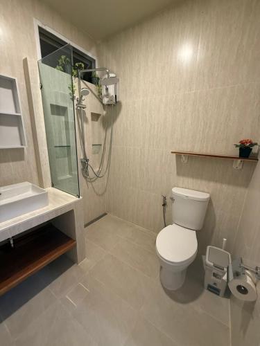a bathroom with a toilet and a shower and a sink at De 8 Huahin in Ban Nong Chaeng