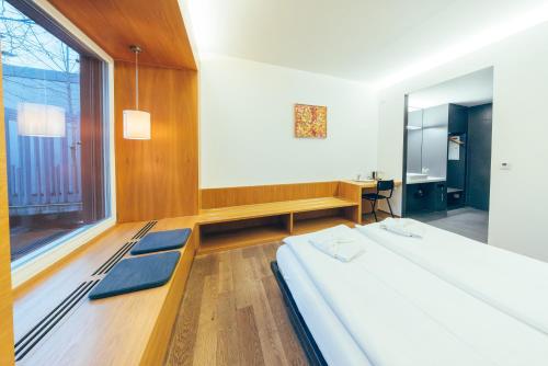 a bedroom with a bed and a desk and a window at Hotel by Hyve Basel in Basel