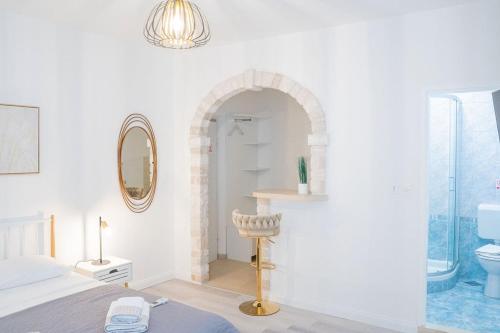 a white room with a bed and a mirror at Pansion Marinka-Bire Rooms in Lumbarda