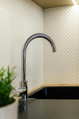 a kitchen sink with a faucet on a counter at Klimatyzowane Apartamenty Miedź i Miód in Bytom Odrzański