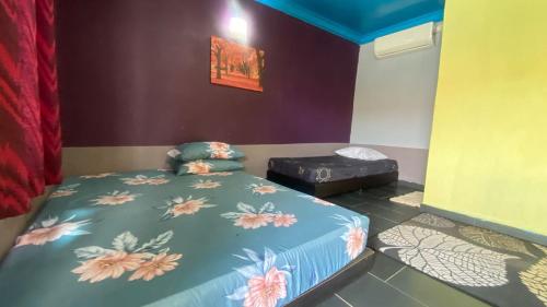 a bedroom with a bed with a flower patterned sheets at Hotel O Green Desa Bayu in Kota