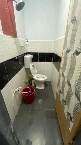 a bathroom with a toilet and a bucket at Hotel O Green Desa Bayu in Kota