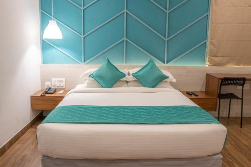 a bedroom with a large bed with blue walls at YC Grand Mystic Premier, Electronic City in Bangalore