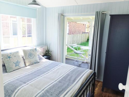 a bedroom with a bed and a large window at Hydaway in Bacton
