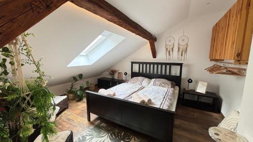 a bedroom with a black bed in a attic at Tanny Boho Housy na pešej zóne in Piešťany