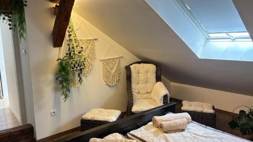 a attic room with two chairs and towels on the wall at Tanny Boho Housy na pešej zóne in Piešťany