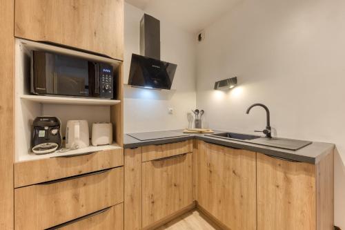 a kitchen with a sink and a microwave at Le splendide - modern & cocooning in Tarbes