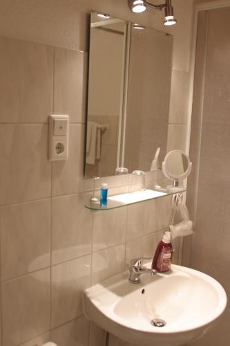 a bathroom with a sink and a mirror at Hotel Alt-Lennep in Remscheid