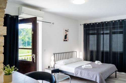 a bedroom with a bed and a table and a window at Pansion Marinka-Bire Rooms in Lumbarda