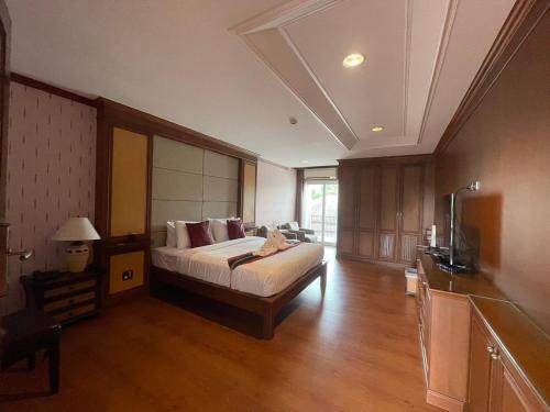 a bedroom with a bed and a television in it at The Canal Ratchaburi in Ratchaburi