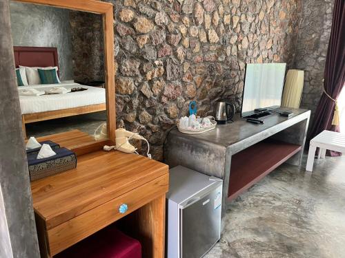 a room with a bedroom with a bed and a mirror at The Canal Ratchaburi in Ratchaburi