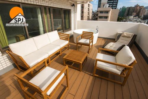 a balcony with a couch and chairs and a table at Landmark Sunshine Hotel in Osaka