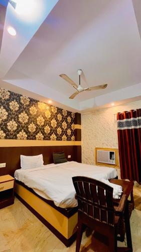 a bedroom with a bed and a ceiling fan at Hotel Crystal Inn in Lucknow