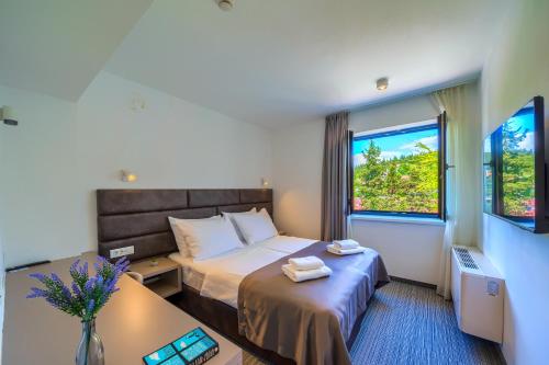 a hotel room with a bed and a window at Hotel Alkar - Family Friendly Hotel with Pool in Sinj, Dalmatia in Sinj