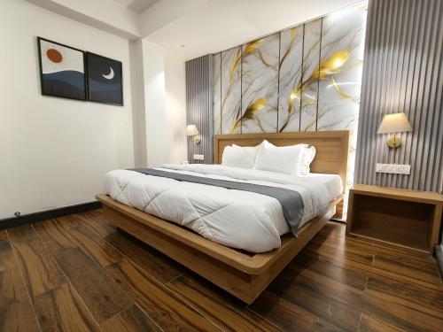 a bedroom with a large bed with a painting on the wall at Paradise Boutique Stays in Solan