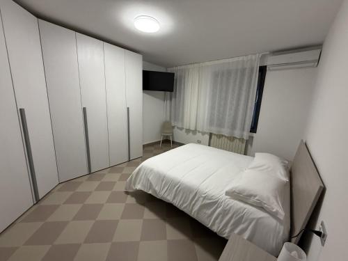 a bedroom with a white bed and a window at Appartamento Centro Direzionale Cerea in Cerea