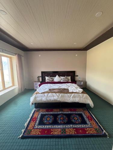 a bedroom with a bed with a rug on the floor at Ostal Residency Pangong in Meruk