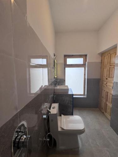 a bathroom with two sinks and a toilet at Ostal Residency Pangong in Meruk