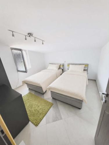 a room with two beds and a yellow rug at Nikita Lux in Lagadin
