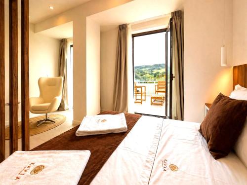 a hotel room with a bed and a chair and a window at Hotel Kavia Sarria in Sarria