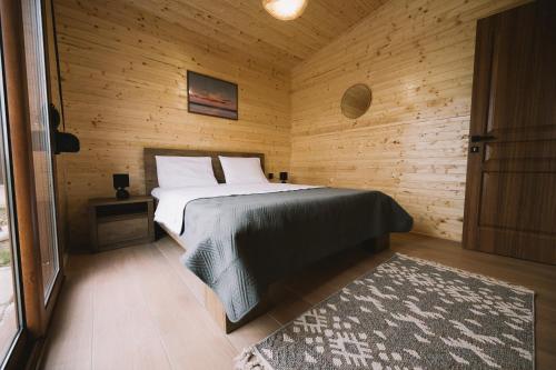a bedroom with a bed in a wooden room at Casa Arte 2 in Ulcinj