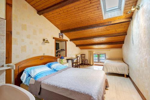 a bedroom with a bed and a wooden ceiling at Chambre d'hôtes La Champagne in Sémussac