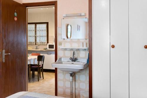 a bathroom with a sink and a kitchen at Chambre d'hôtes La Champagne in Sémussac