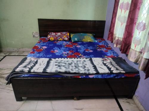 a bed with a blue comforter and pillows on it at Jp Homestay in Vrindāvan