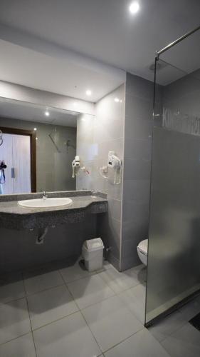 a bathroom with a sink and a toilet and a mirror at King Tut Aqua Park Beach Resort in Hurghada