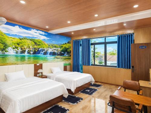 two beds in a room with a waterfall mural at Panda Hotel in Long Thành