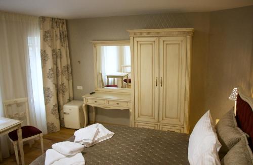 a bedroom with a bed with a dresser and a mirror at Hotel Schlossberg in Meißen