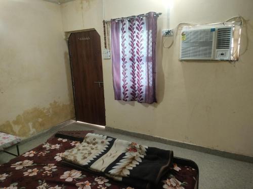 a room with a window and a bed with a blanket at Jp Homestay in Vrindāvan