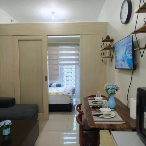 a living room with a table and a bed at Condo unit open for staycation in Manila