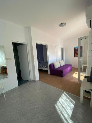 a living room with a purple couch in a room at Apartments Olea in Rab