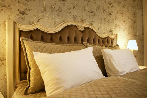 a bedroom with a bed with white pillows at Hotel Schlossberg in Meißen
