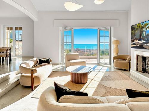 a living room with white furniture and a fireplace at Sea View Villa Roc d'Azur - Pool - Jacuzzi in Vallauris