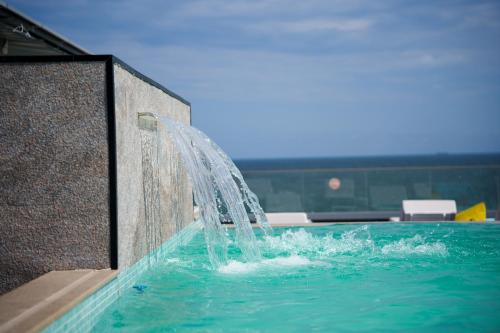 a water fountain in a swimming pool at Superior Jacuzzi Apartment Sea Side Terrace in Eforie Nord