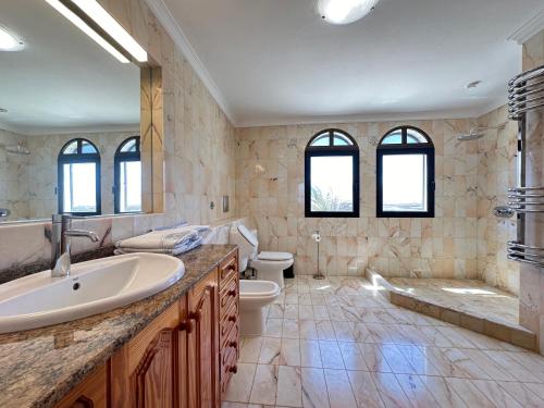 a bathroom with a sink and a toilet and a tub at Casa Ronda in Charco del Palo
