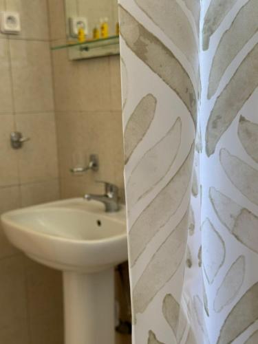 a bathroom with a sink and a shower curtain at Kofini Falassarna in Falasarna