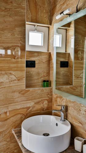 a bathroom with a white sink and a mirror at Hotel Corali in (( Spile ))