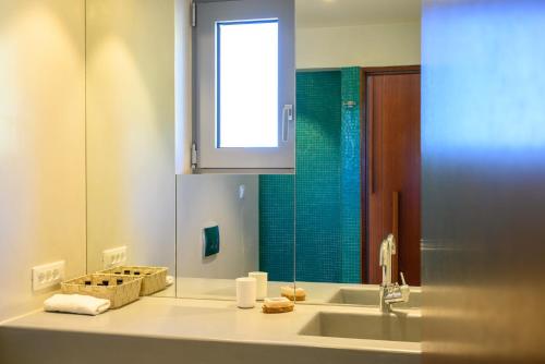 a bathroom with a sink and a mirror at Luxury Villa with Panoramic Sea Views in Thólos